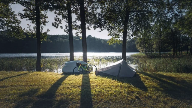 Ein Bikepacking Rad und ein Zelt vor einem See