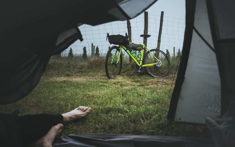 Blick aus einem Zelt auf ein Bikepacking Rad